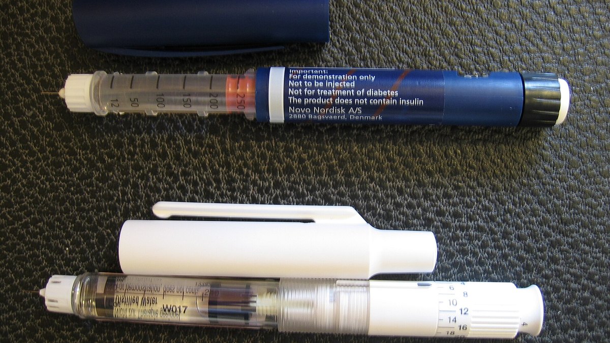 Pen injectors opened to show the internal cartridge and the graduated dose dial — the metering half of a dual-chamber pen's fresh-mix-then-dose action; a Panacea Bio Chem illustration for the EZnject pen by Bogdan Dicoias